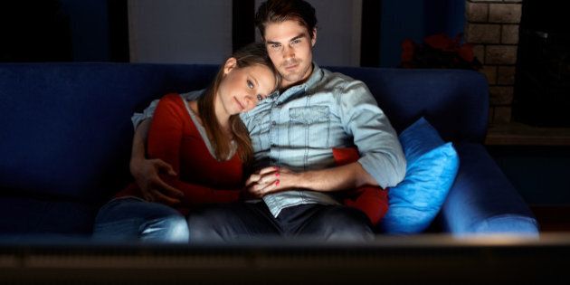 man and woman watching movie on tv