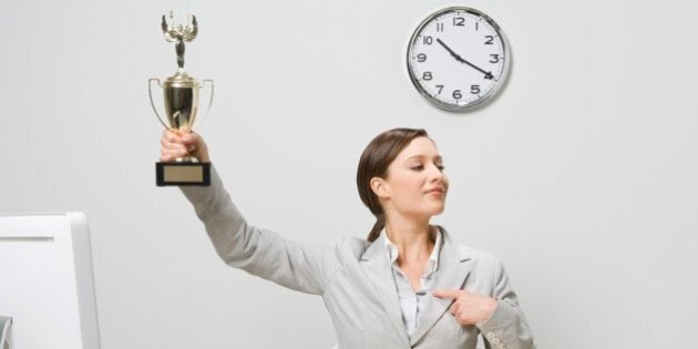 Businesswoman holding trophy