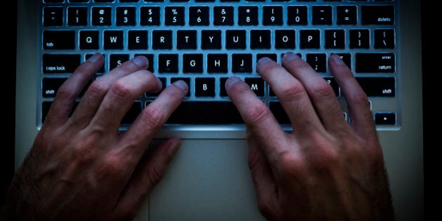 Hacker typing on the computer in the darkness of the night. Top view, horizontal framing.