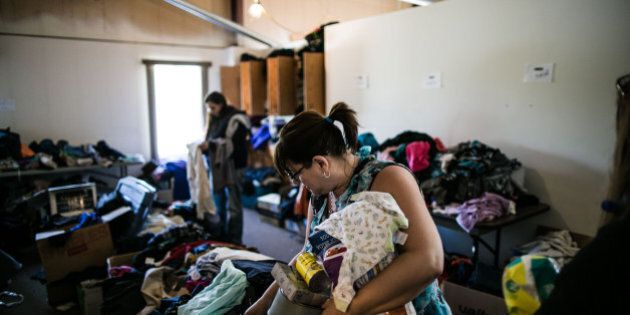FORT MCMURRAY - May 12, 2016: Evacuees look through donated items at a camp located in Wander River community where more than 400 evacuees are living, 200 km south of Fort McMurray, Alberta, Canada - May 11, 2016. More than 1,500 firefighters have been battling the blaze, with the help of 150 helicopters, and 28 air tankers. More than 88,000 evacuees are living in camps, community centres and temporary homes. (Xinhua/Amru Salahuddien via Getty Images)