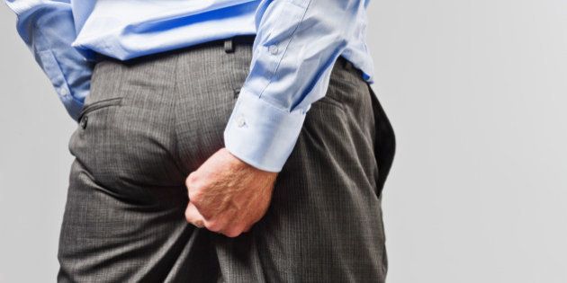 Rude businessman scratches his buttocks - NOT something to do in public!
