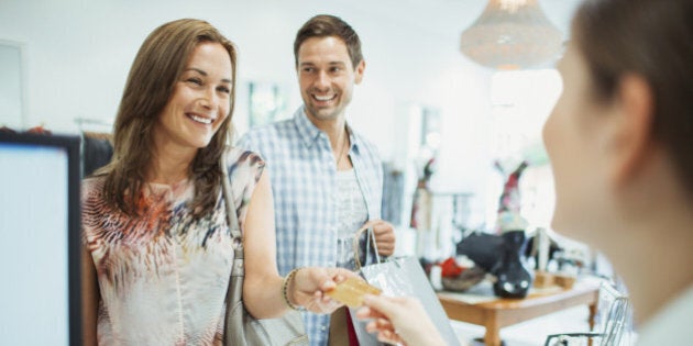 Couple paying with credit card in clothing store