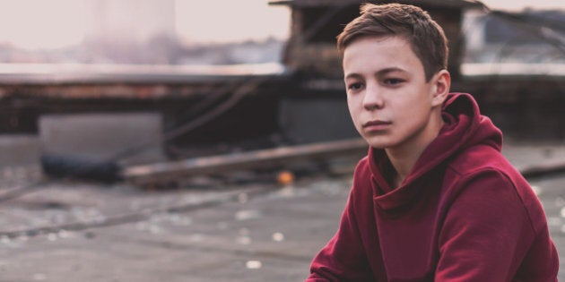 Lonely teenager sitting on roof the house