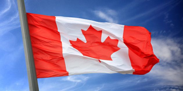 The Canadian flag against the blue sky