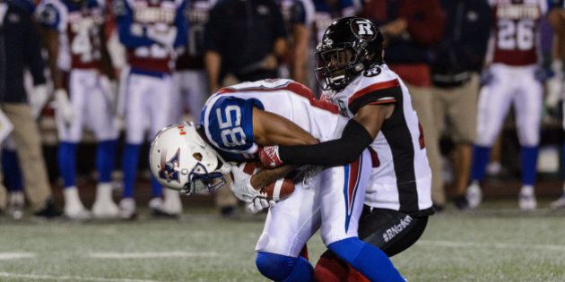 MONTREAL, QC - SEPTEMBER 01: Defensive back Nicholas Taylor #28 of the Ottawa Redblacks grabs a hold of wide receiver B.J. Cunningham #85 of the Montreal Alouettes during the CFL game at Percival Molson Stadium on September 1, 2016 in Montreal, Quebec, Canada. The Ottawa Redblacks defeated the Montreal Alouettes 19-14. (Photo by Minas Panagiotakis/Getty Images)