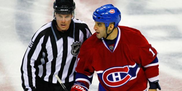 Montreal Canadiens center Scott Gomez is led to the penalty box by linesman David Brisebois during the third period of NHL hockey action against the Atlanta Thrashers in Montreal, March 29, 2011. REUTERS/Shaun Best (CANADA - Tags: SPORT ICE HOCKEY)