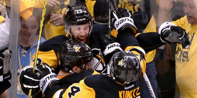 Pittsburgh Penguins' Nick Bonino (13) is greeted by Ian Cole (28) and Chris Kunitz (14) after scoring against the Washington Capitals during overtime of Game 6 of the NHL hockey Stanley Cup Eastern Conference semifinals, Tuesday, May 10, 2016 in Pittsburgh. The Penguins won 4-3 to advance to the conference finals. (AP Photo/Gene J. Puskar)