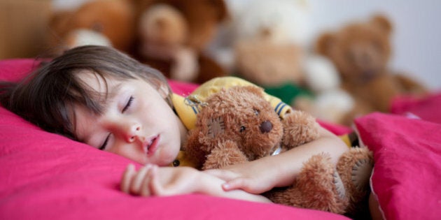 Sweet little boy, sleeping in the afternoon with his teddy bear toy