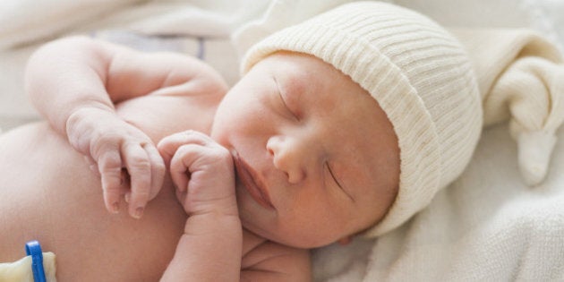 Caucasian newborn baby laying on blanket