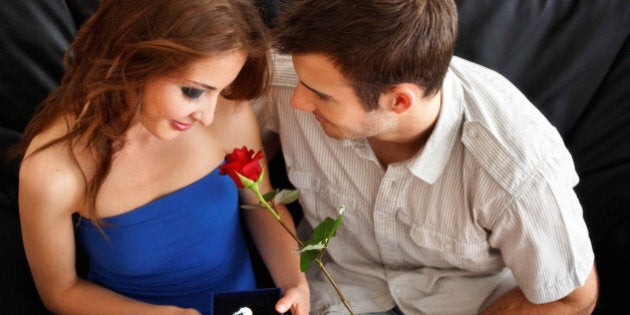 Young man's gifts for Valentine's day to his girfriend - a single rose and a crystal heart - late teenager heterosexual couple