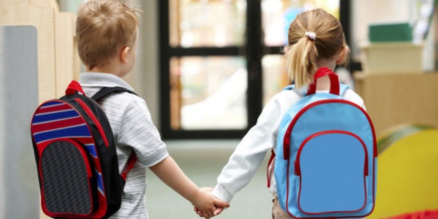 Two cute little children walking to school - Rear view