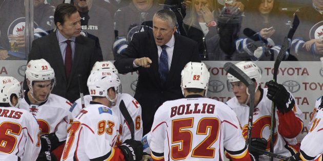 WINNIPEG, MB - OCTOBER 16: Bob Hartley, head coach of the Calgary Flames, speaks to his team from the bench in third period action in an NHL game against the Winnipeg Jets at the MTS Centre on October 16, 2015 in Winnipeg, Manitoba, Canada. (Photo by Marianne Helm/Getty Images)