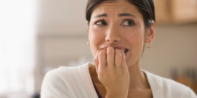 Afraid mixed race woman biting fingers