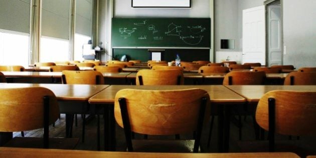 A large, empty classroom, lit by morning light.