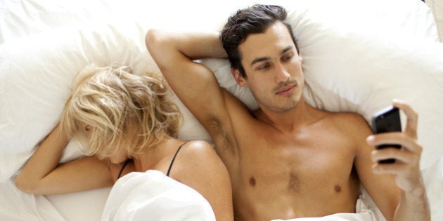 Man texting SMS on mobile phone in bed