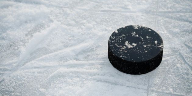 Hockey puck on ice hockey rink on shiny winter day