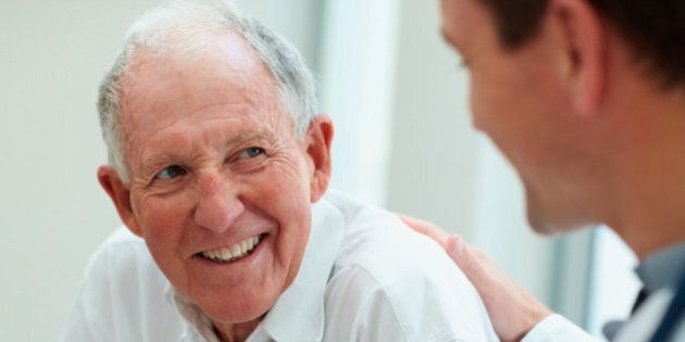Happy old man having a casual talk with a doctor