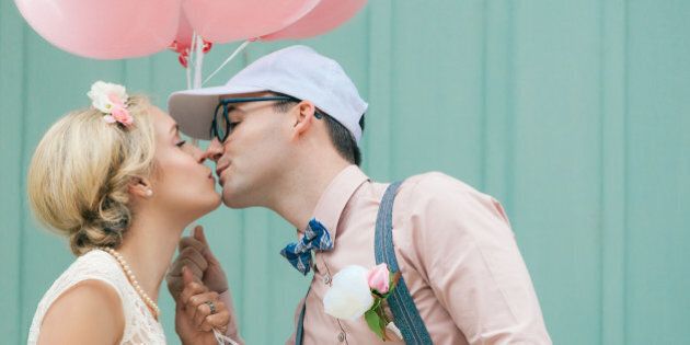 Wedding, romantic couple kissing, in retro, vintage style, with balloons.