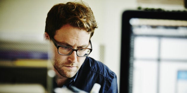 Businessman working on project on laptop in startup office