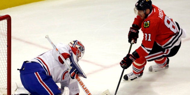 Montreal Canadiens goalie Ben Scrivens, left, saves a shot by Chicago Blackhawks right wing Marian Hossa during the first period of an NHL hockey game Sunday, Jan. 17, 2016, in Chicago. (AP Photo/Nam Y. Huh)