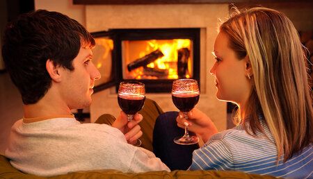 49559063 - Couple buvant du vin face à un foyer