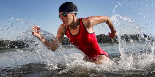 Female triathlete running out of water after swim