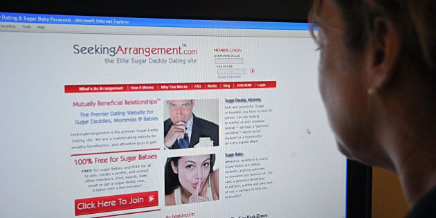 This August 9, 2011 photo shows a journalist reading the SeekingArrangement.com dating website in Washington, DC. - On one hand, a man of a certain age, with deep pockets. On the other, a young woman, cute and penniless. Sugar Daddy and Sugar Baby will be able to meet and 'hug' via a website that speaks American money without complexes, but rejects the word prostitution. AFP PHOTO / Karen BLEIER (Photo credit should read KAREN BLEIER/AFP/Getty Images)