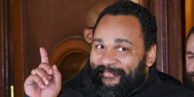 French comedian Dieudonne M'Bala M'Bala gestures to the media as he leaves a Paris court house, Wednesday, Feb. 4, 2015. Controversial French comic Dieudonne has gone on trial charged with