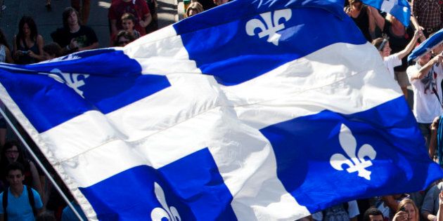 A flag of Quebec is seen as thousands of demonstrators march against student tuition fee hikes in downtown Montreal, August 22, 2012. REUTERS/Olivier Jean (CANADA - Tags: CIVIL UNREST POLITICS EDUCATION BUSINESS)