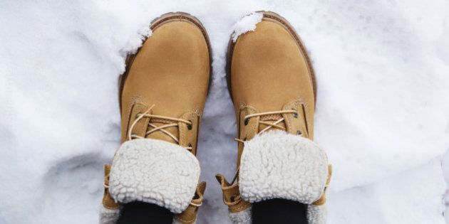 Pair brown boots in white fresh snow