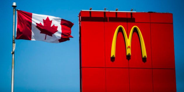 A Canadian flag waves beside McDonalds fast food restaurant in Toronto, May 1, 2014. About 400,000 people came to Canada under the government's temporary foreign worker program, which is designed to fill jobs for which there are no qualified Canadian candidates. The program has been hugely popular with employers, ballooning from 100,000 workers in 2002. But the backlash against it has also grown as the program, initially designed to help the booming resource industry, has expanded to lower-skilled jobs, especially at restaurant chains such as McDonald's Corp and Tim Hortons Inc. To match Feature CANADA-EMPLOYMENT/TEMPORARY REUTERS/Mark Blinch (CANADA - Tags: BUSINESS EMPLOYMENT FOOD POLITICS)