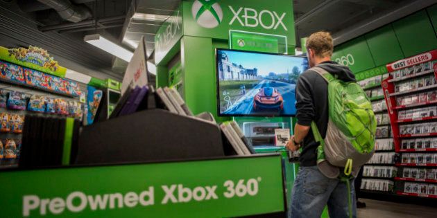 A customer plays a Microsoft Corp. Xbox 360 video game at a GameStop Corp. store in San Francisco, California, U.S., on Tuesday March 24, 2015. GameStop Corp. is scheduled to release earnings figures on March 26. Photographer: David Paul Morris/Bloomberg via Getty Images
