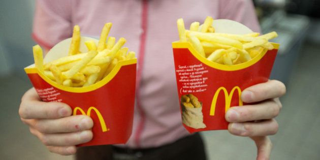 An employee holds two packets of french fries in this arranged photograph at McDonald's Corp.'s 505th Russian fast food restaurant on its opening day at the Central Children's Mall in Moscow, Russia, on Thursday, June 11, 2015. Europe was a bright spot for a company struggling with sluggish demand in both Asia and its home country. Photographer: Andrey Rudakov/Bloomberg via Getty Images