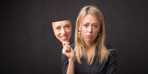 Woman holding mask of her happy face