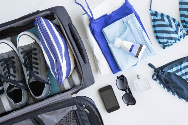 Overhead view of suitcase being packed for vacation