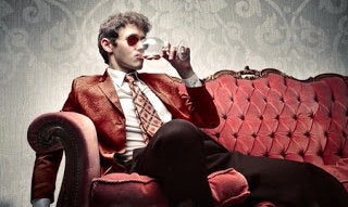 10171766 - young man sitting on a sofa and drinking a glass of wine