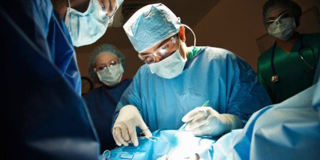 Surgeons performing C-Section in operating room.