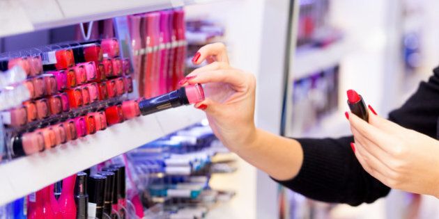 Woman shopping for red lipstick at department store