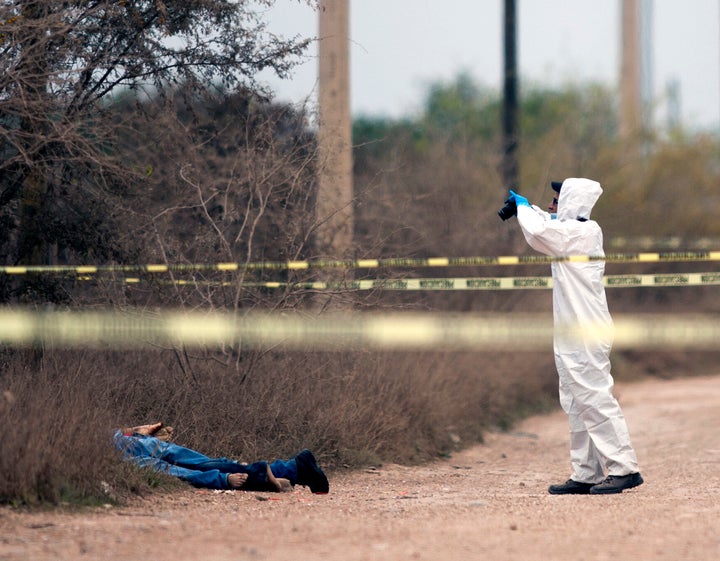 Un policía investiga la escena de un crimen en México.
