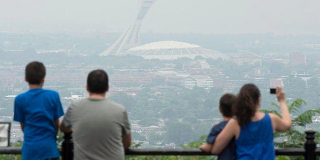 Des touristes photographient le Stade olympique à l'été 2013, un jour de smog.