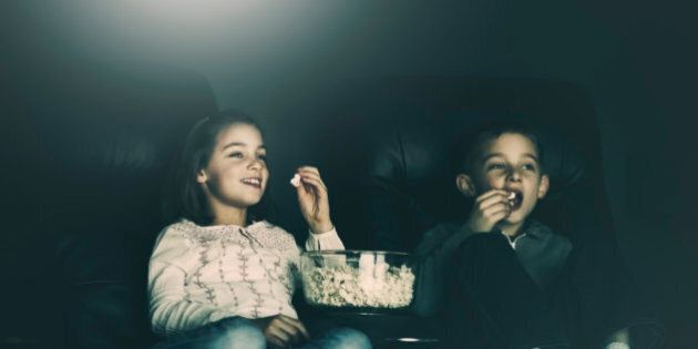 boy and girl, eating popcorn, watching a movie in their home theater