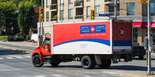 TORONTO, ONTARIO, CANADA - 2015/08/13: Red and white color Canada Post delivery truck passing through a traffic junction. Canada Post or Postes Canada, is the crown corporation which functions as the country's primary postal operator. It was earlier known as Royal Mail Canada. (Photo by Roberto Machado Noa/LightRocket via Getty Images)