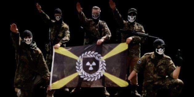 Des membres de la division Atomwaffen, un groupe néonazi violent, posent avec leur drapeau à thème nucléaire.
