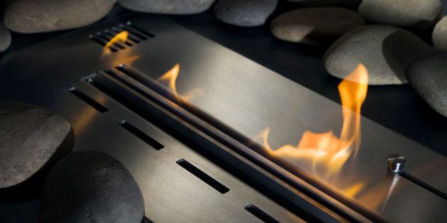 Bio-fireplace with fire, laid out around a smooth stone, close-up