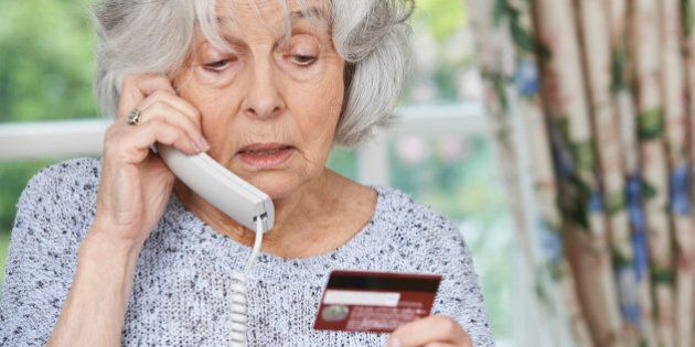 Senior Woman Giving Credit Card Details On The Phone