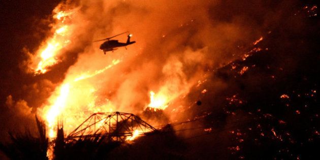 A Los Angeles County fire helicopter makes a night drop while battling the so-called Fish Fire above Azusa, California, U.S. June 20, 2016. REUTERS/Gene Blevins