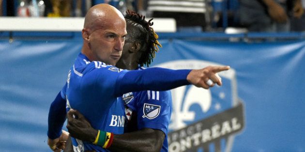 Jul 25, 2015; Montreal, Quebec, CAN; Montreal Impact defender Laurent Ciman points to a team mate as he is hugged by forward Dominic Oduro (7) after scoring in the second half to give the Impact a 1-0 win over Seattle Sounders at Stade Saputo. Mandatory Credit: Dan Hamilton-USA TODAY Sports