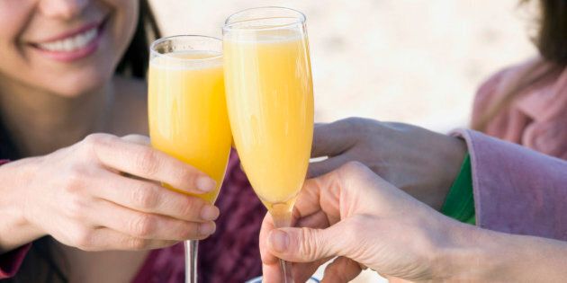 Multi-ethnic women toasting with mimosas