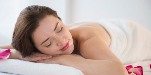 Woman with eyes closed on spa table