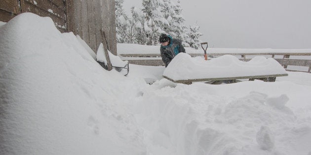 Un employé s'affaire à dégager une terrasse de plus de 50 centimètres de neige mercredi au Mont Sutton en Estrie.